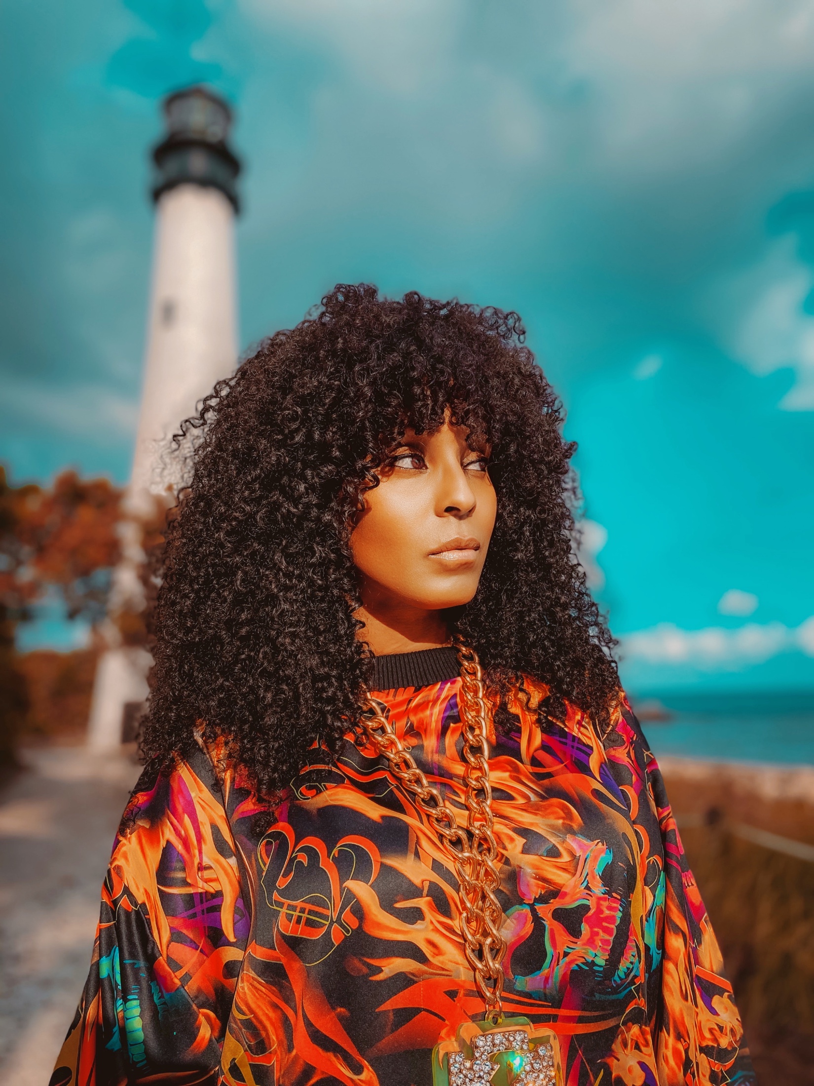 Angela Hunte in a vivid patterned top near the water